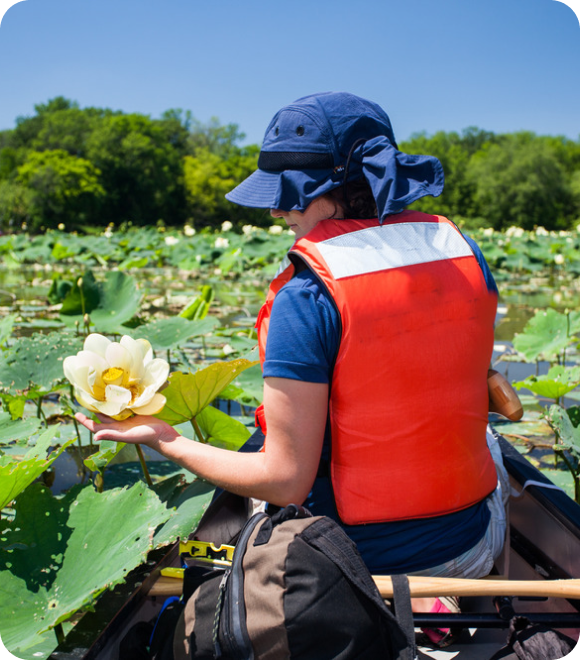 Person in safety vest working in pond