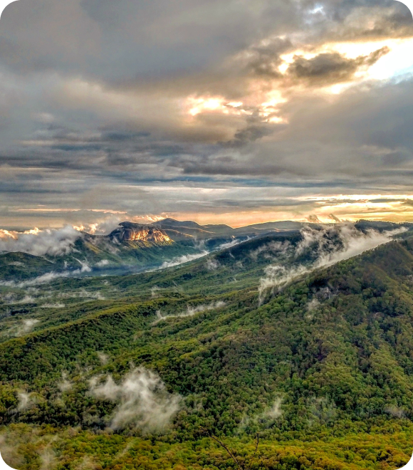 Hills with sun diffusing through clouds